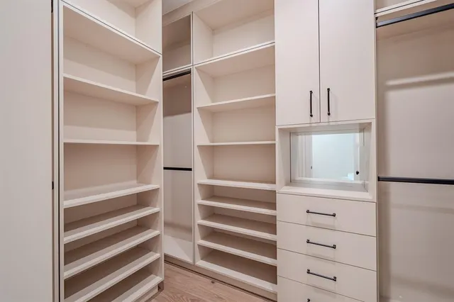 a view of closet with white cabinets