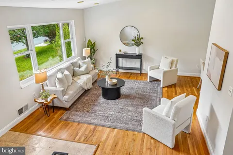 a living room with furniture fireplace and a large window
