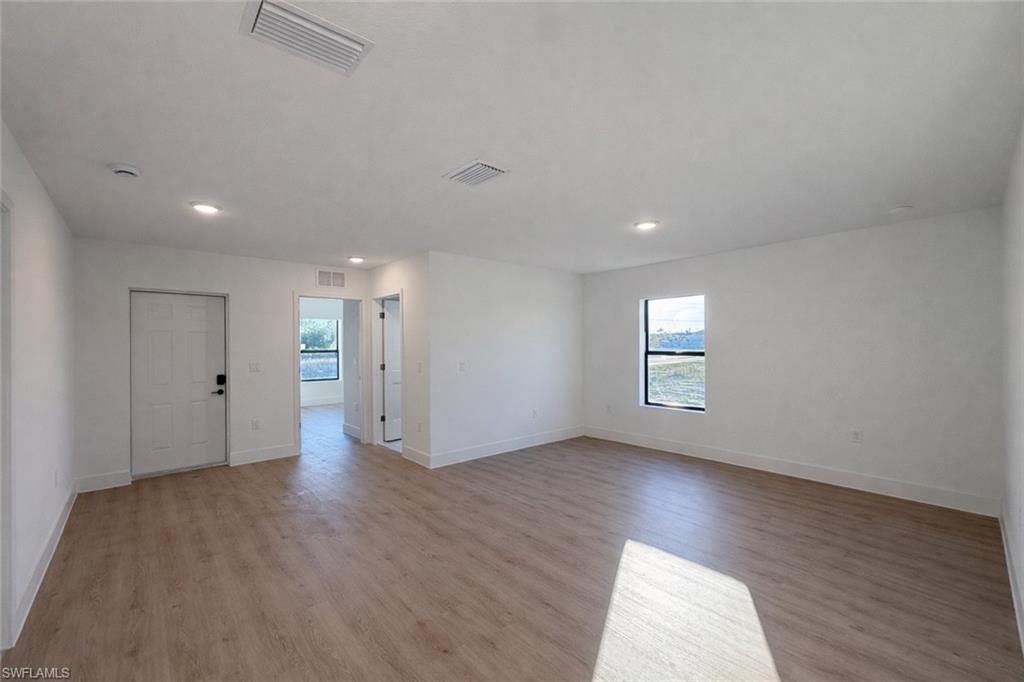 2812 23rd Street Southwest Lehigh Acres, FL 33976 - Photo 13 of 17 an empty room with wooden floor and windows