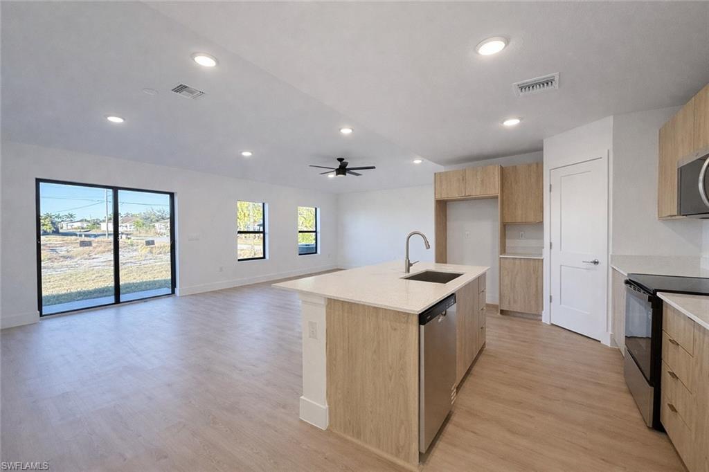 2812 23rd Street Southwest Lehigh Acres, FL 33976 - Photo 16 of 17 an open kitchen with a sink and a stove top oven