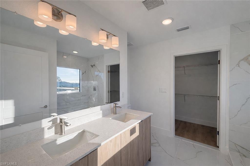 2812 23rd Street Southwest Lehigh Acres, FL 33976 - Photo 7 of 17 a bathroom with a sink a vanity and a mirror