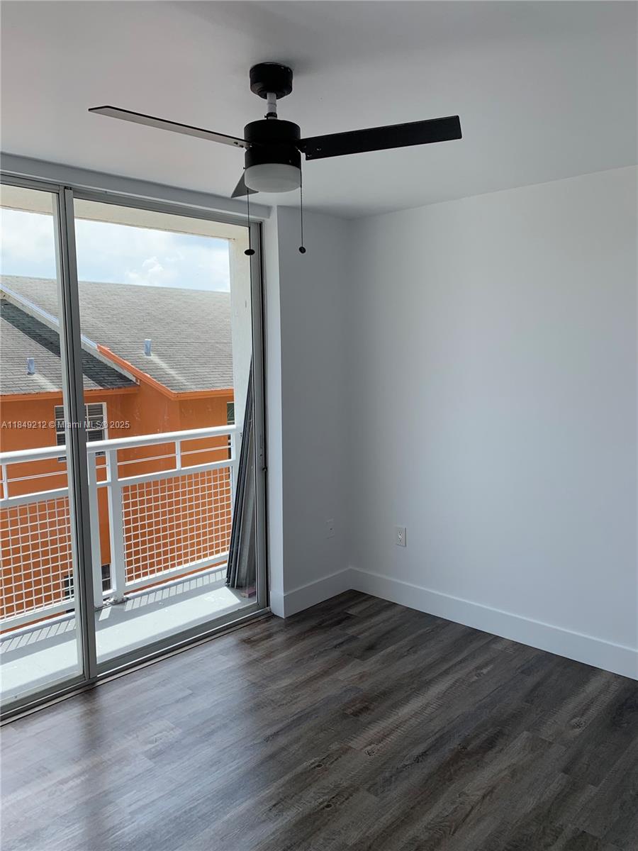 450 Southwest 3rd Street, Unit 10 Miami, FL 33130 - Photo 11 of 13 an empty room with wooden floor and windows