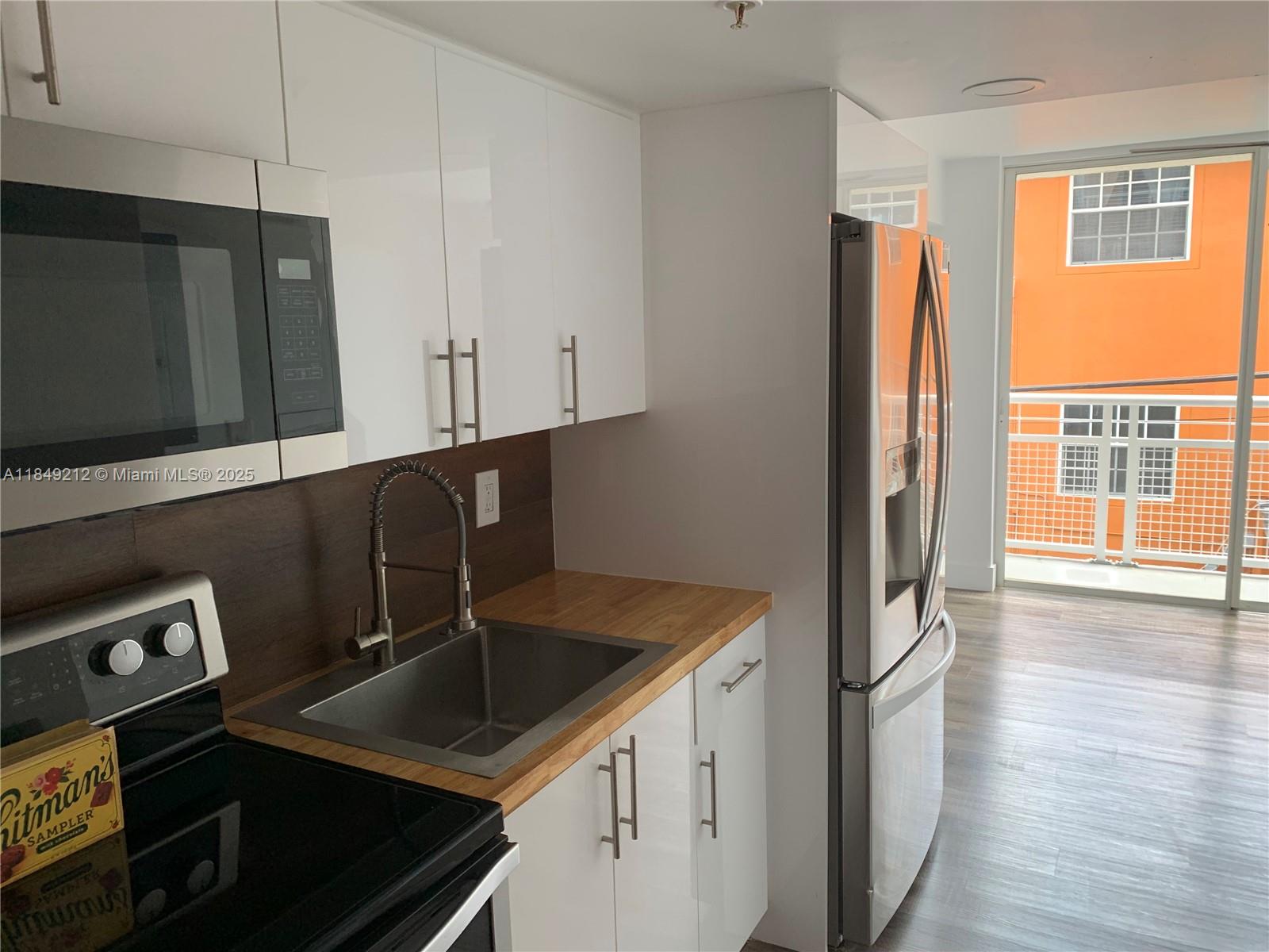 450 Southwest 3rd Street, Unit 10 Miami, FL 33130 - Photo 2 of 13 a kitchen with stainless steel appliances granite countertop a refrigerator and a sink