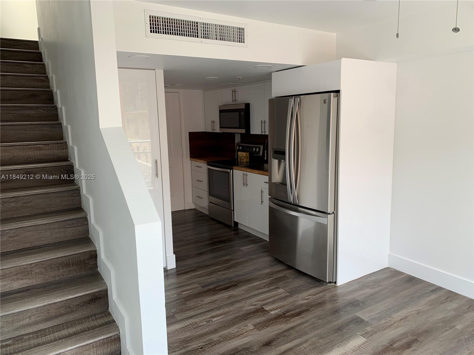 450 Southwest 3rd Street, Unit 10 Miami, FL 33130 - Photo 3 of 13 a kitchen with stainless steel appliances a refrigerator and a stove top oven