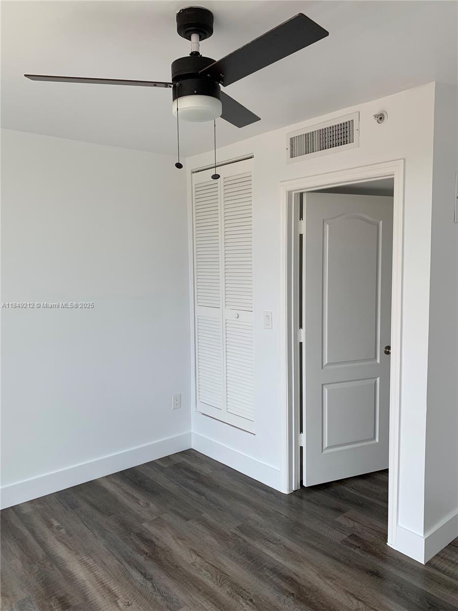 450 Southwest 3rd Street, Unit 10 Miami, FL 33130 - Photo 10 of 13 a view of an empty room with wooden floor and a ceiling fan