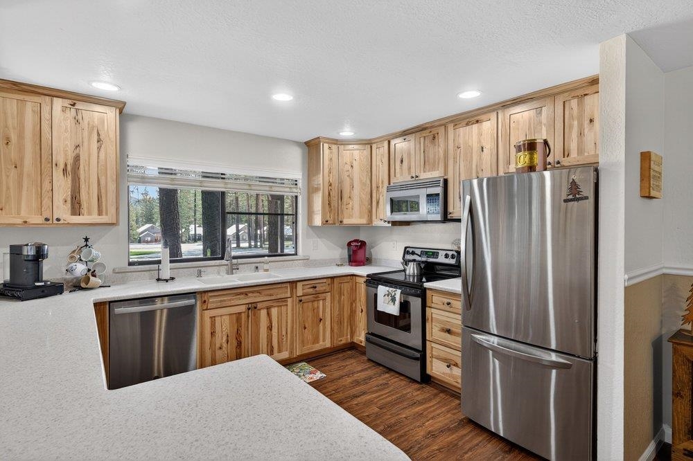 112 Poplar Valley Road Blairsden, CA 96103 - Photo 9 of 28 a kitchen with stainless steel appliances granite countertop a refrigerator a sink dishwasher a stove and white countertops with wooden floor