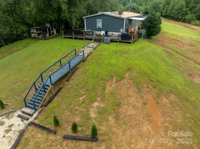 a small pool with lawn chairs and wooden fence