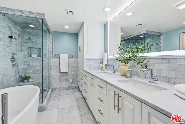 a spacious bathroom with a granite countertop sink mirror and a bathtub