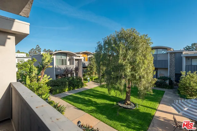 a view of a house with a yard and potted plants