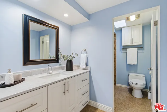 a bathroom with a toilet sink and mirror