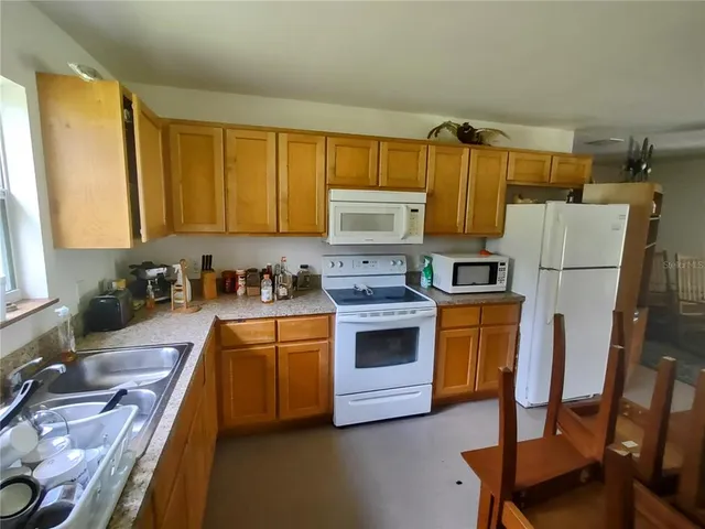 a kitchen with stainless steel appliances granite countertop a refrigerator a stove a sink dishwasher and a stove with wooden floor