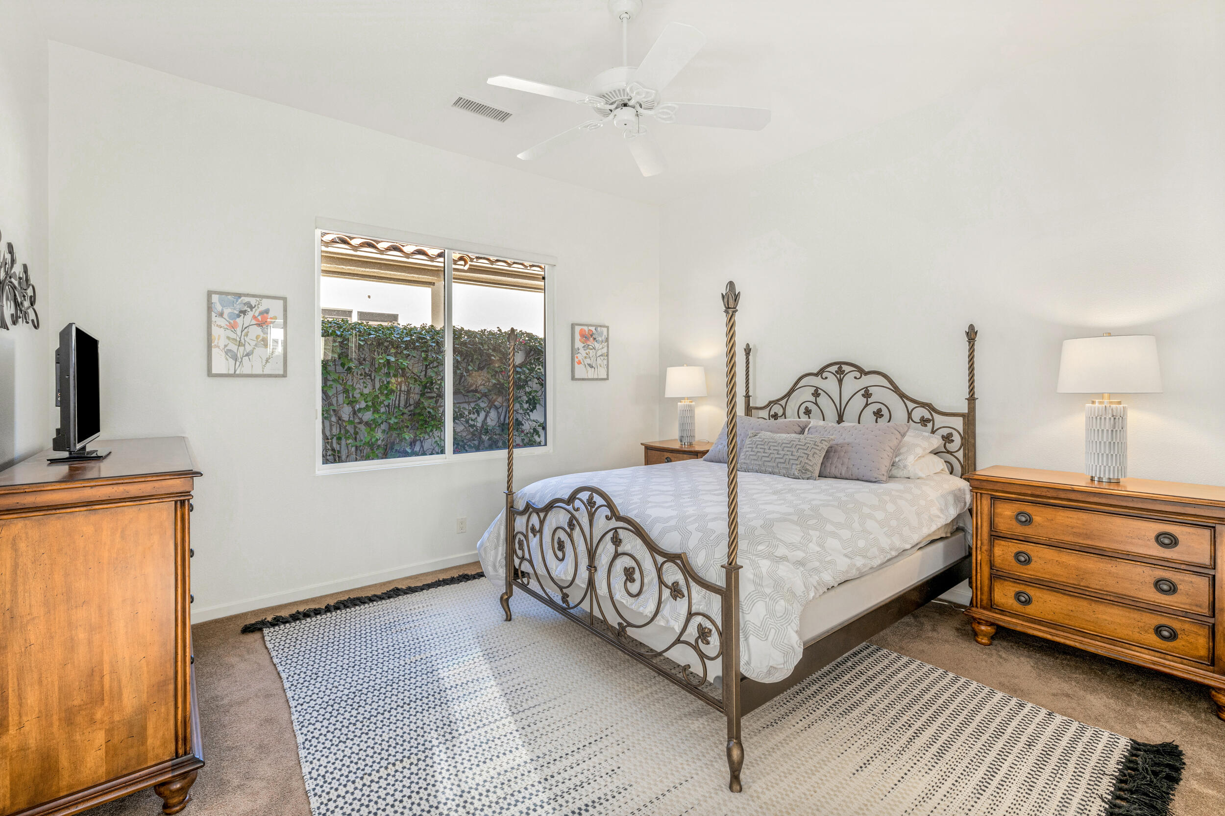 701 Indian Ridge Drive Palm Desert, CA 92211 - Photo 27 of 40 a bedroom with a bed a dresser and with a flat tv screen