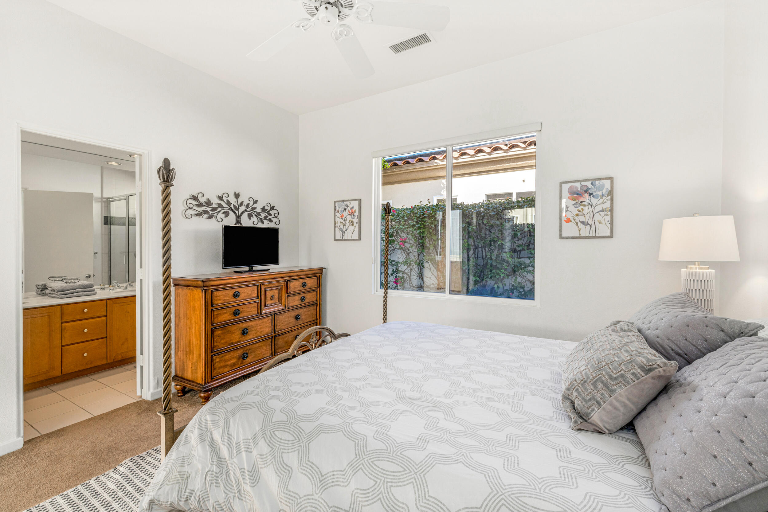 701 Indian Ridge Drive Palm Desert, CA 92211 - Photo 28 of 40 a large bedroom with a bed and a flat tv screen on dresser
