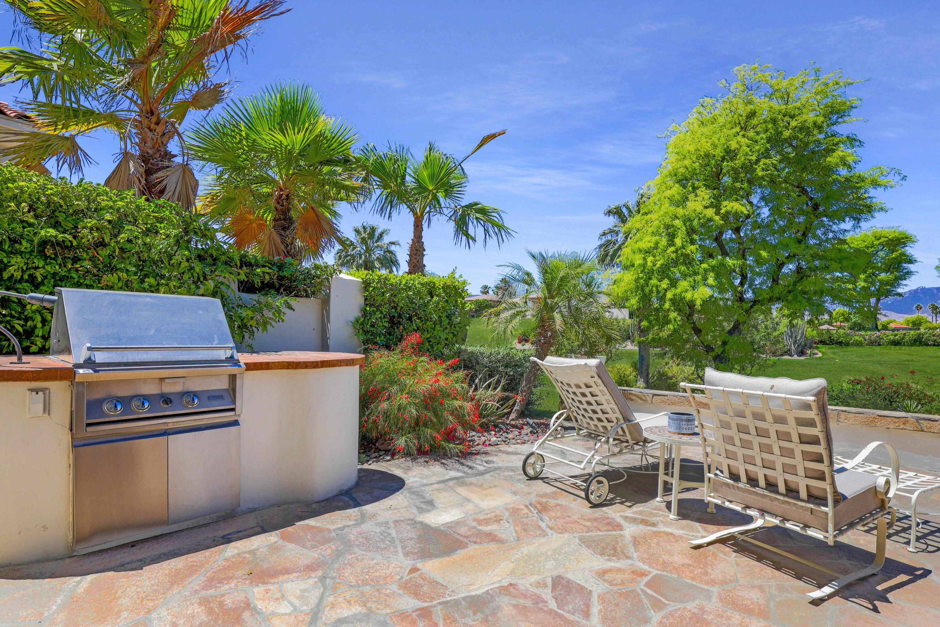 701 Indian Ridge Drive Palm Desert, CA 92211 - Photo 37 of 40 a view of a chairs and table in a backyard