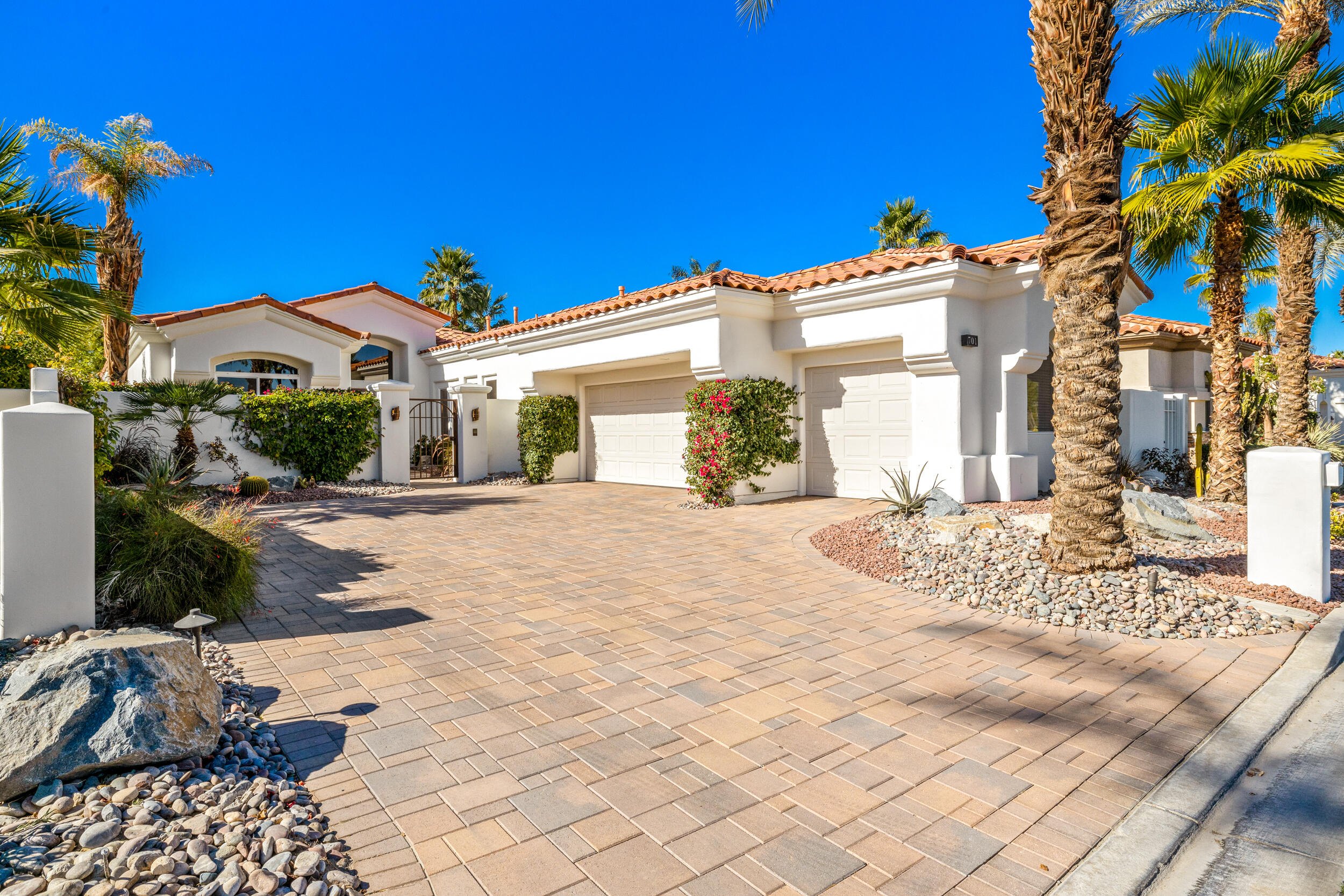 701 Indian Ridge Drive Palm Desert, CA 92211 - Photo 5 of 40 a view of a white house with a yard and potted plants