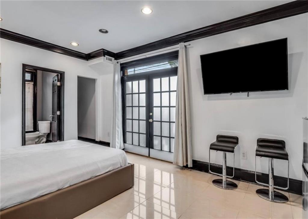 2846 Piedmont Road Northeast, Unit 1 Atlanta, GA 30305 - Photo 4 of 29 a bedroom with a bed and a flat screen tv