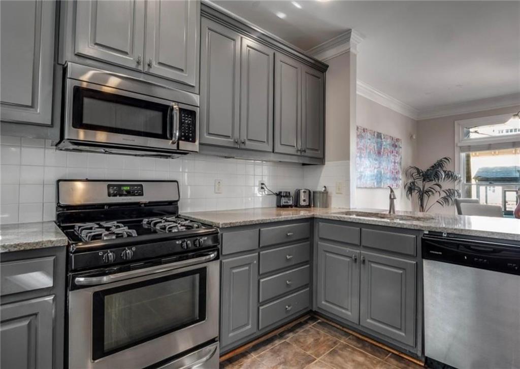 2846 Piedmont Road Northeast, Unit 1 Atlanta, GA 30305 - Photo 10 of 29 a kitchen with stainless steel appliances granite countertop grey cabinets a stove a sink and dishwasher