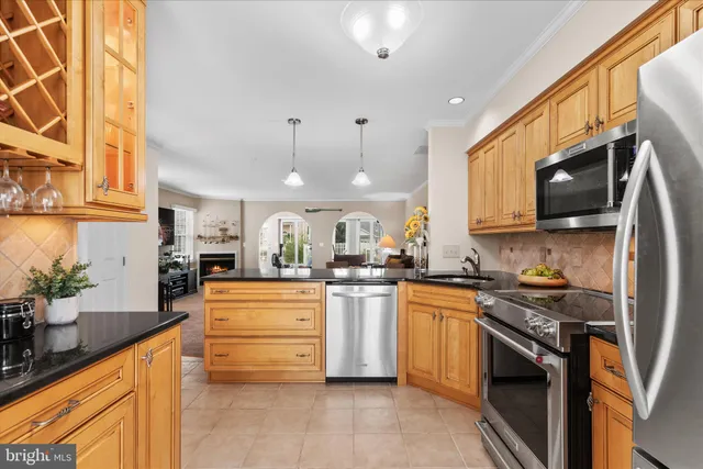 a kitchen with stainless steel appliances granite countertop a stove a sink dishwasher and a refrigerator
