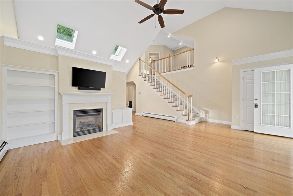14 Sugar Maple Circle, Unit 14 Hanover, MA 02339 - Photo 10 of 38 a view of a livingroom with a fireplace a ceiling fan and wooden floor