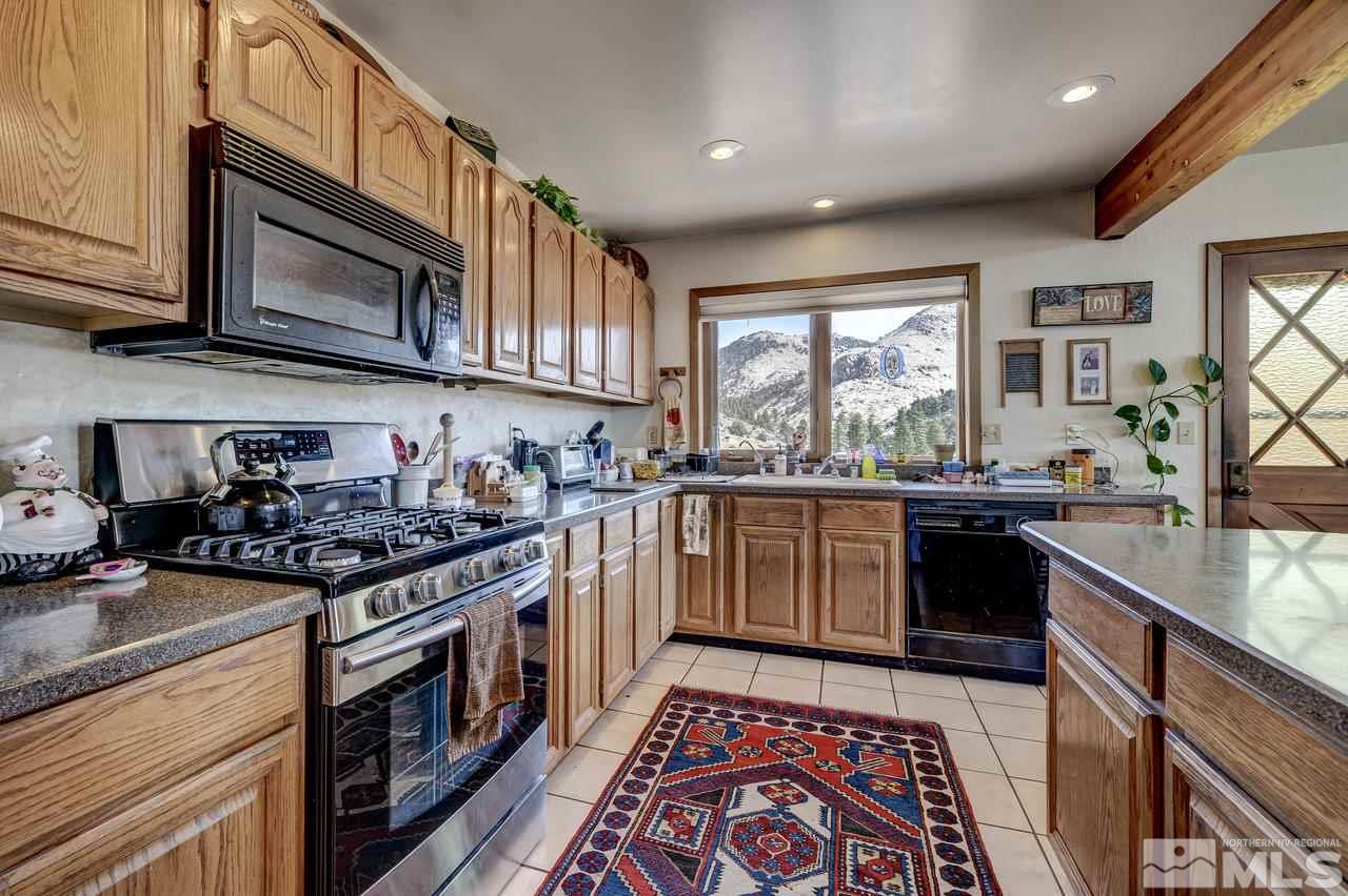 16500 Toll Road Reno, NV 89521 - Photo 9 of 25 a kitchen with stainless steel appliances granite countertop a stove a sink and a microwave