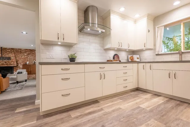 a kitchen with stainless steel appliances granite countertop a stove a sink and white cabinets