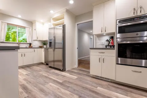 a kitchen with white cabinets and appliances