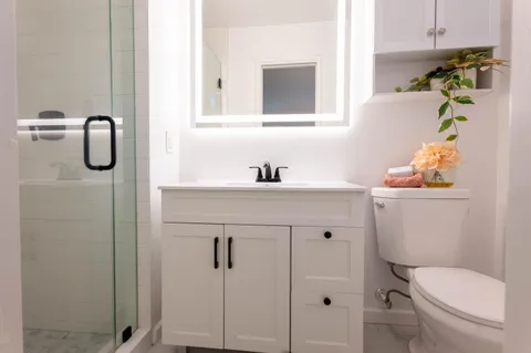 a bathroom with a sink vanity mirror and toilet