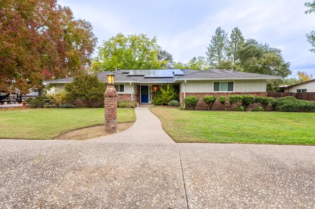 a view of a house with a yard and potted plants
