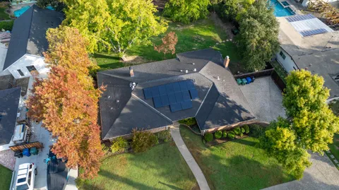 an aerial view of a house with a yard and swimming pool