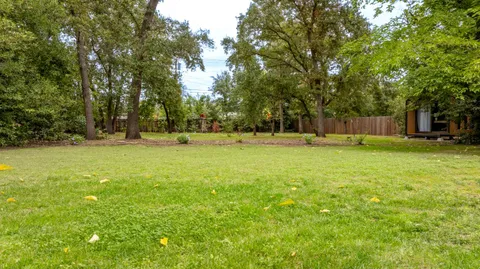 a backyard of a house with lots of green space and fountain