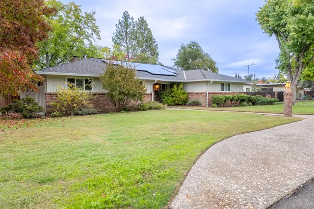 a front view of a house with yard and green space