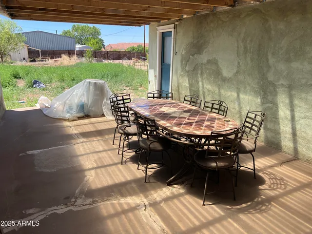a view of a patio with table and chairs with wooden floor and fence