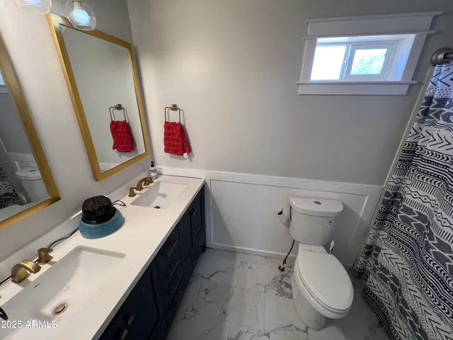 a bathroom with a sink vanity mirror and toilet