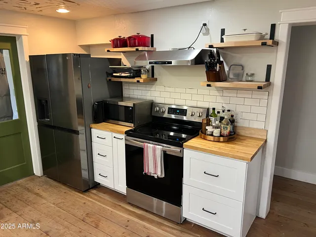 a kitchen with stainless steel appliances granite countertop a refrigerator and a stove