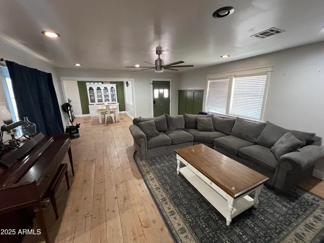 a living room with furniture a chandelier and a flat screen tv