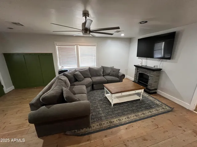 a living room with furniture a flat screen tv and a fireplace