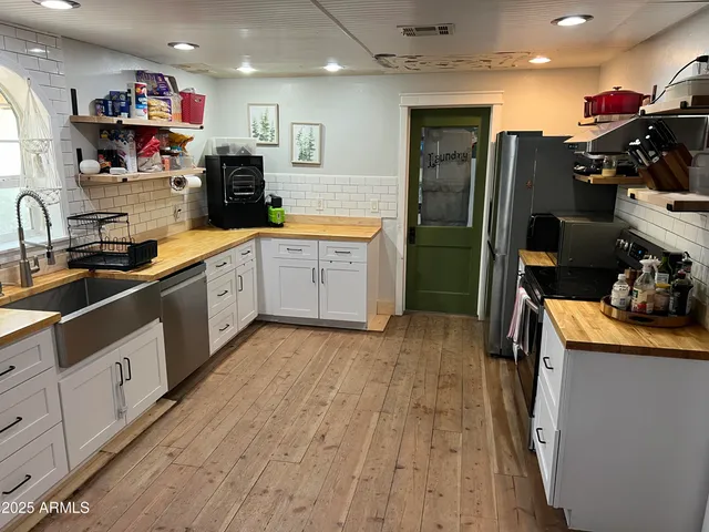 a kitchen that has a lot of cabinets a sink and appliances in it