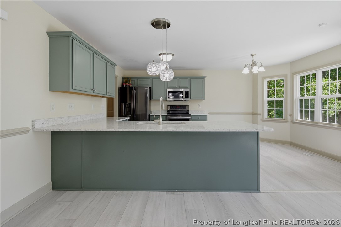 1075 Buffalo Lake Road Sanford, NC 27332 - Photo 18 of 49 a kitchen with a sink and chandelier