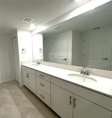 a bathroom with double sink and a mirror