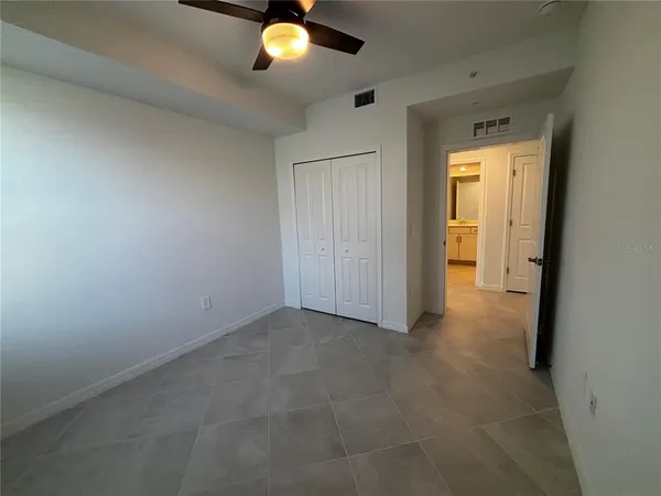 an empty room that has a window and a potted plant