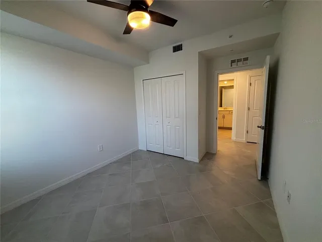 an empty room that has a window and a potted plant