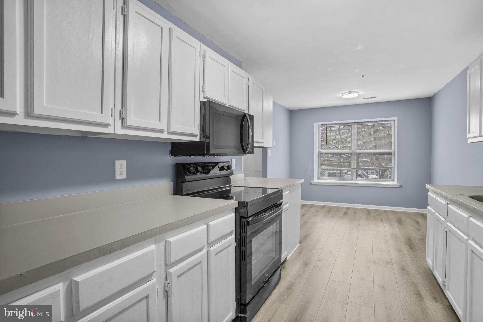 11206 Hannah Way, Unit 4 Upper Marlboro, MD 20774 - Photo 13 of 25 a kitchen with stainless steel appliances granite countertop a stove a sink and a microwave