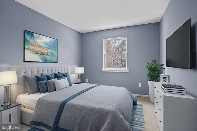 a bedroom with a bed a couch and a flat screen tv