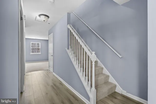 a view of staircase with wooden floor and fan