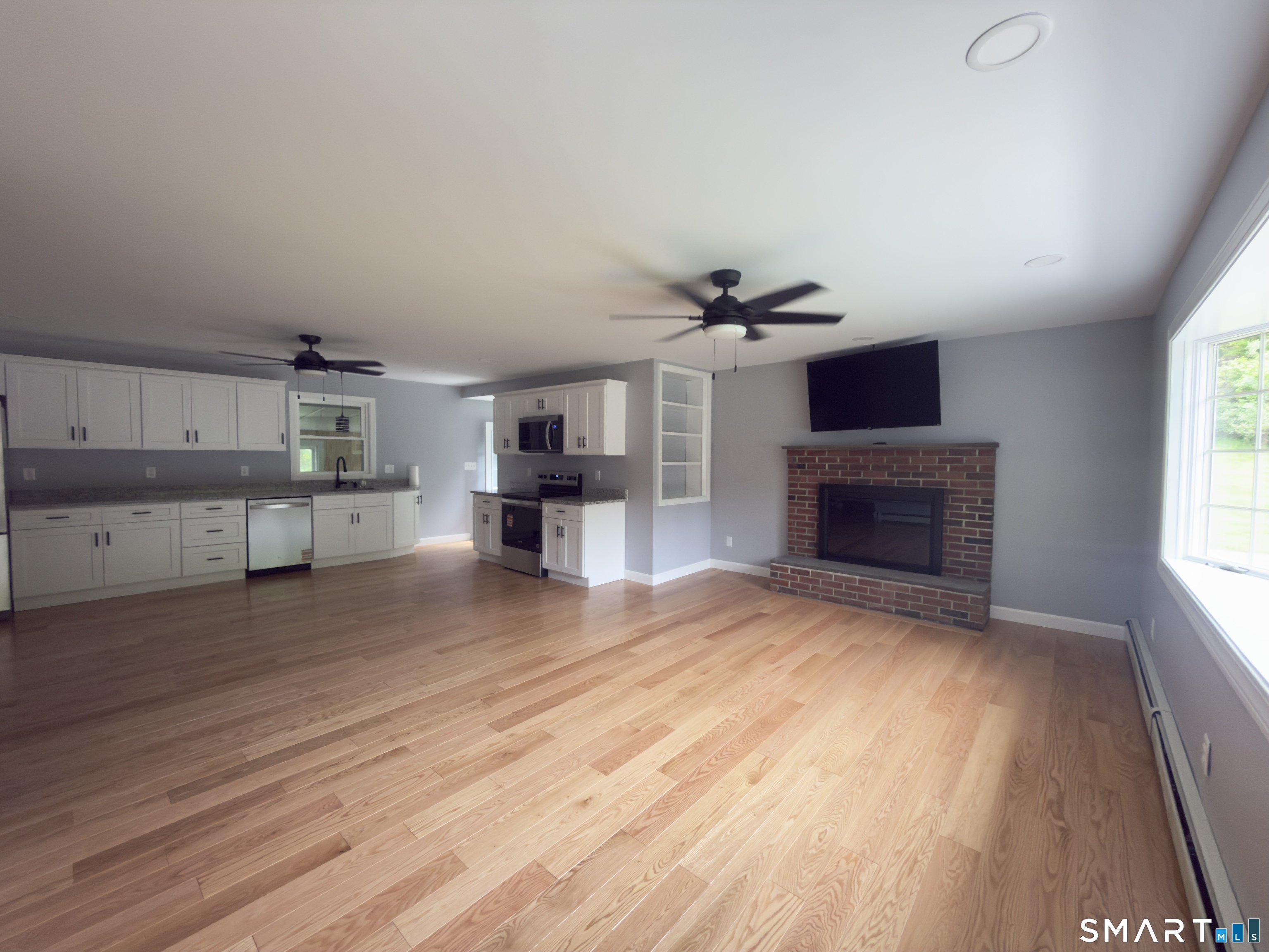 44 Polly Avenue Killingly, CT 06239 - Photo 11 of 22 wooden floor in kitchen and a livingroom with a fireplace