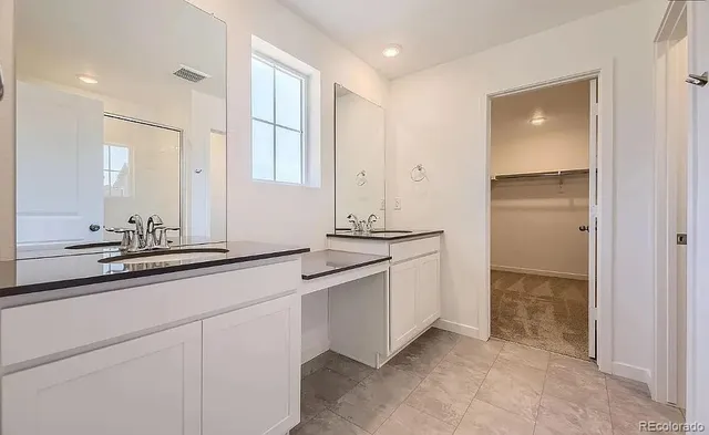 a bathroom with a double vanity sink and a mirror