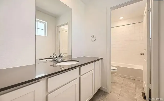 a bathroom with a shower sink and mirror