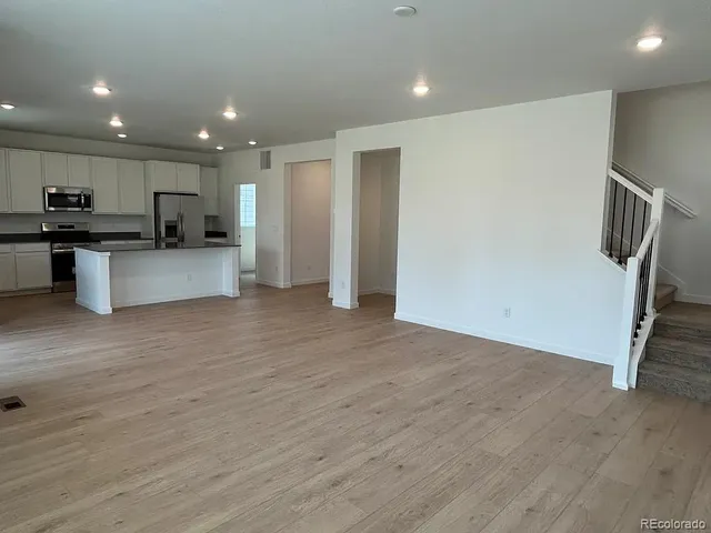 a large kitchen with stainless steel appliances granite countertop a sink and a large window