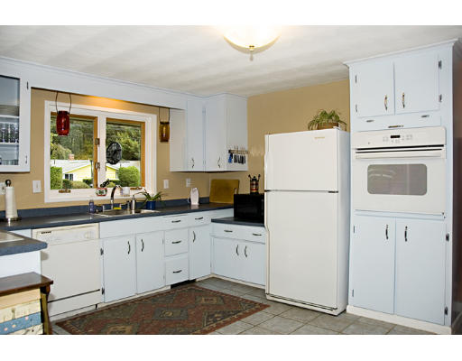 73 Joseph Road Framingham, MA 01701 - Photo 4 of 19 a kitchen with granite countertop a refrigerator a sink a stove and white cabinets