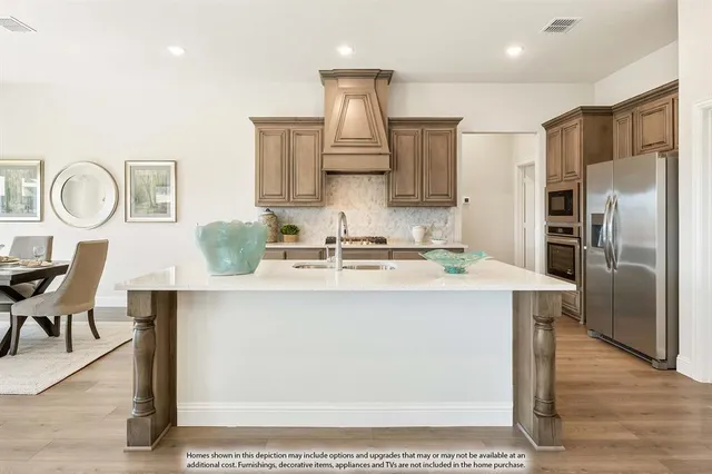 a kitchen with stainless steel appliances granite countertop a sink a stove and a refrigerator